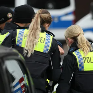 Zwei Polizistinnen und zwei männliche Kollegen von hinten fotografiert