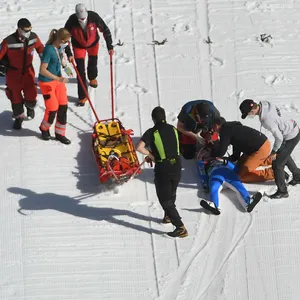 Sanitäter und Ersthelfer kümmern sich um einen gestürzten Skispringer.
