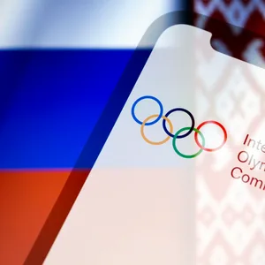 Handy mit Olympischen Ringen vor russischer Flagge