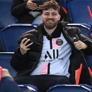 Anton Rinas (ViscaBarca) sitzt lächelnd auf der Tribüne im Stadion.