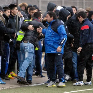 Fans und Spieler streiten sich am Spielfeldrand.