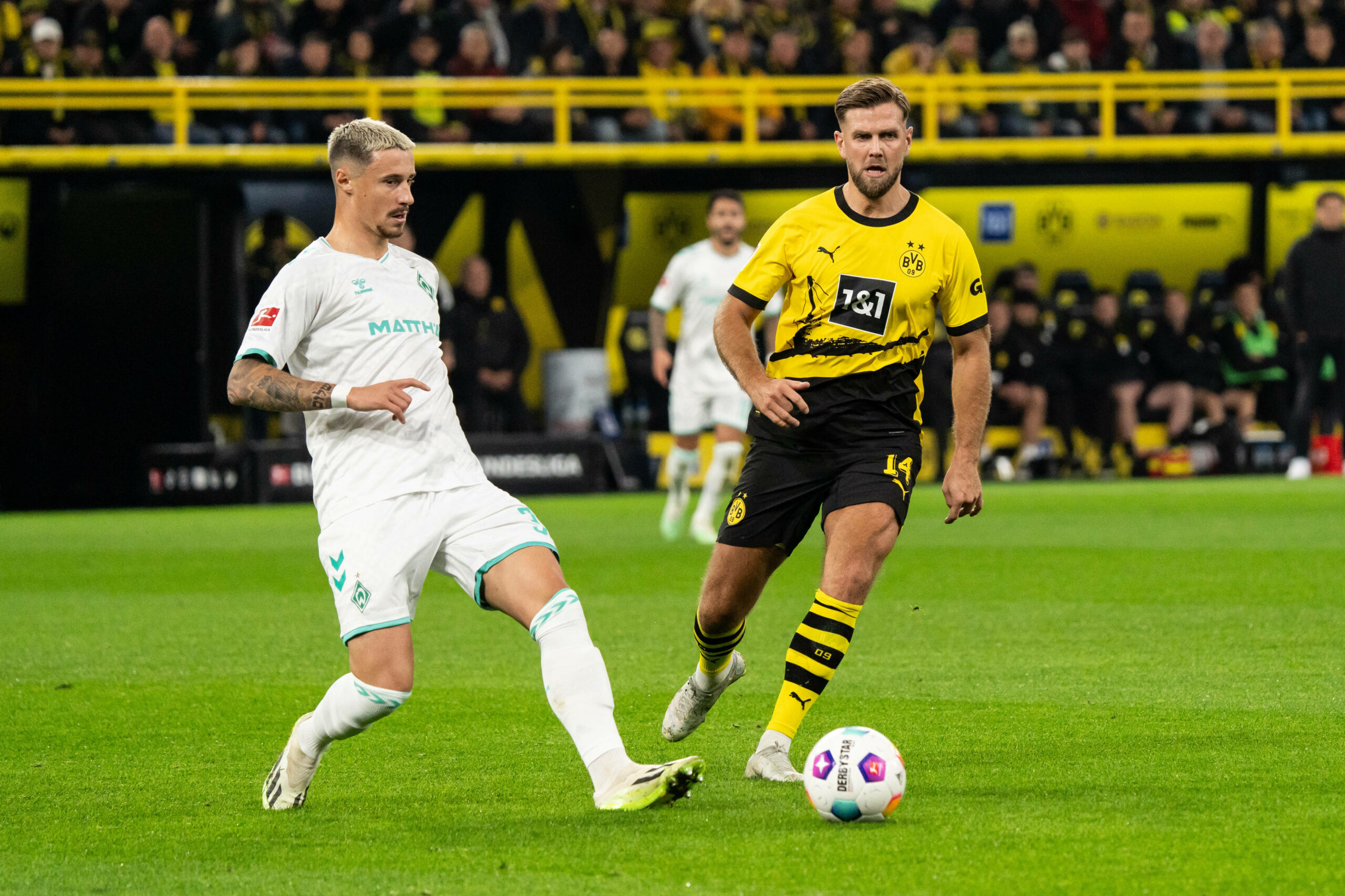 Niclas Füllkrug will Marco Friedl den Ball abnehmen.