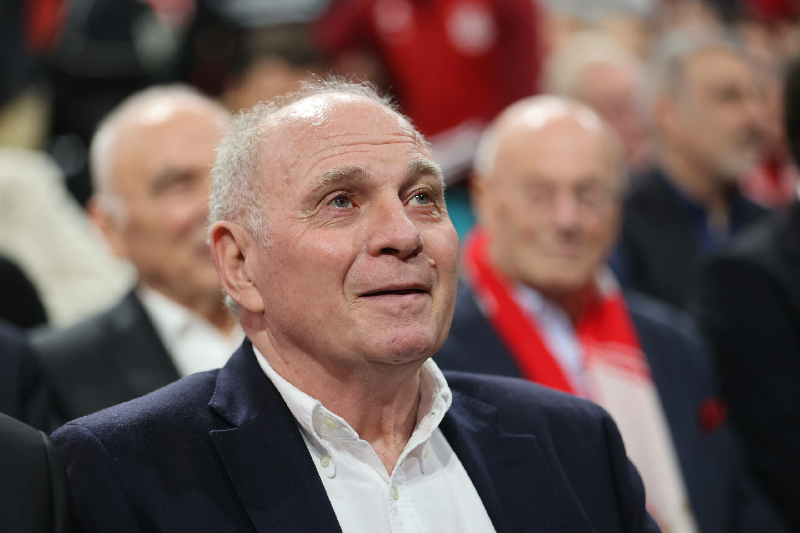 Uli Hoeneß sitzt im Anzug im Publikum einer Veranstaltung.