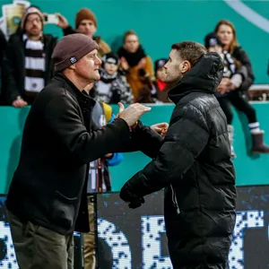 Präsident Oke Göttlich beim Handschlag mit St. Paulis Trainer Fabian Hürzeler (