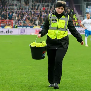 Eine Ordnerin schleppt in Osnabrück Tennisbälle vom Platz