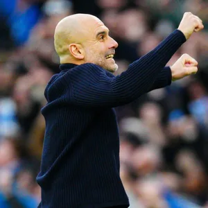 Pep Guardiola jubelt mit den Fäusten in der Höhe und einem Lächeln im Gesicht.