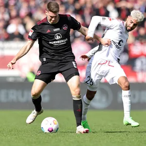 Elias Saad im Zweikampf mit Nürnbergs Florian Flick