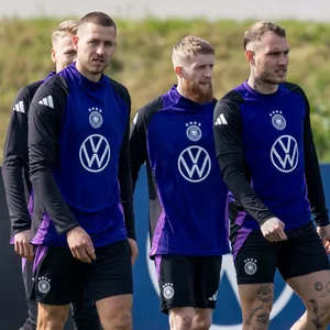 Jan-Niklas Beste, Robert Andrich, David Raum und Waldemar Anton gehen beim DFB-Training nebeneinander über den Platz