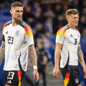 Robert Andrich (l.) und Toni Kroos blicken im Länderspiel gegen Frankreich konzentriert über den Platz