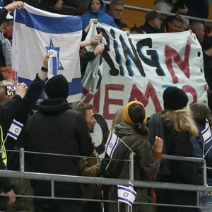 Fans halten ein politisches Banner hoch.