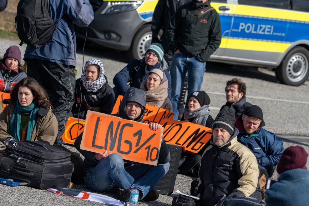 Klimaaktivisten der Letzten Generation blockieren die Zufahrtsstraße zum Hafen Mukran in Sassnitz auf Rügen.