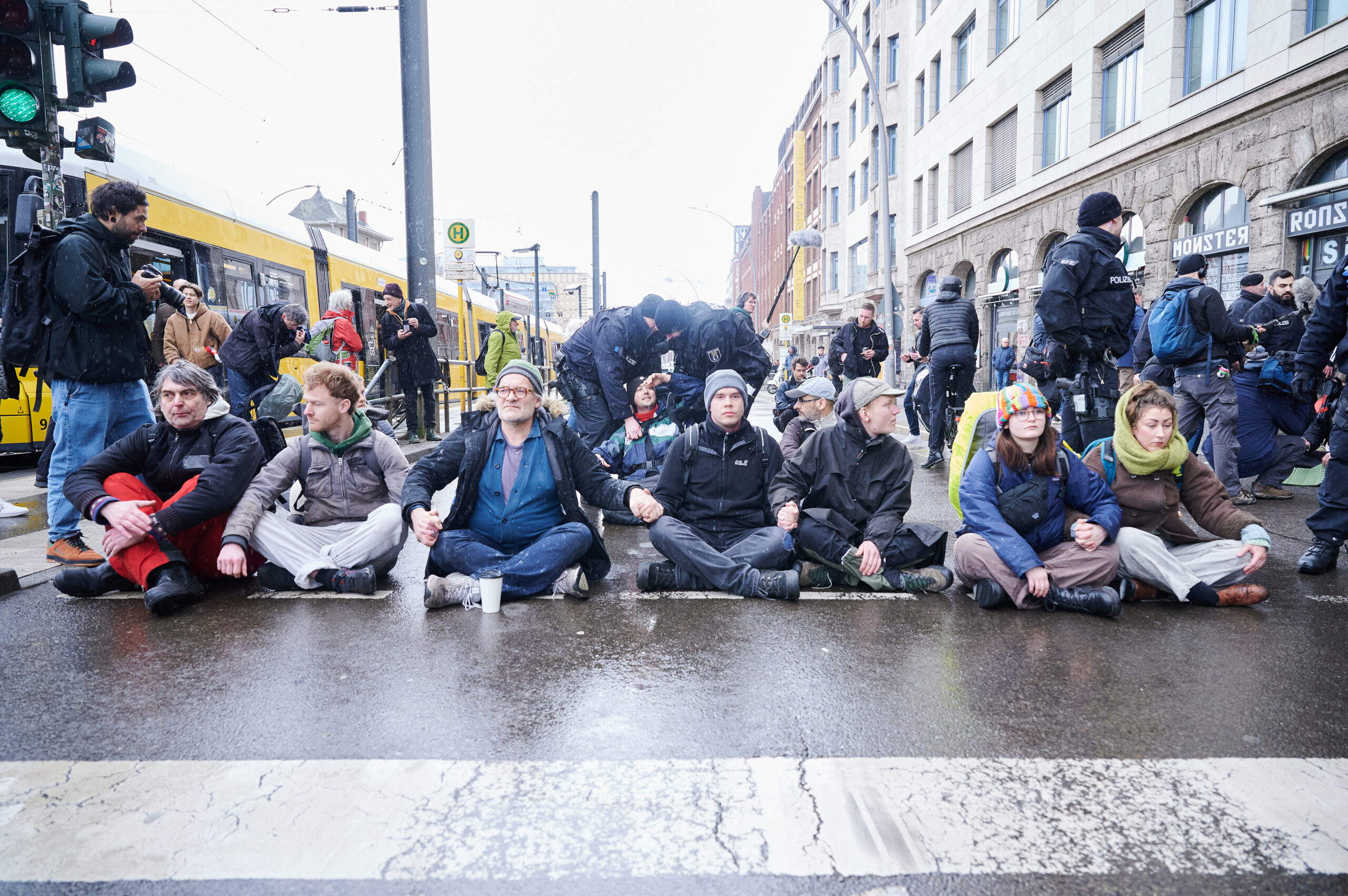 Polizisten ziehen Klimaaktivisten der Letzten Generation von einer Straße in Berlin.