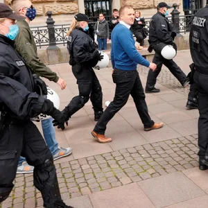 Der Hamburger NPD-Vorsitzende Lennart Sebastian Stefan Schwarzbach wird bei einer Demo im Jahr 2020 von Polizisten eskortiert.