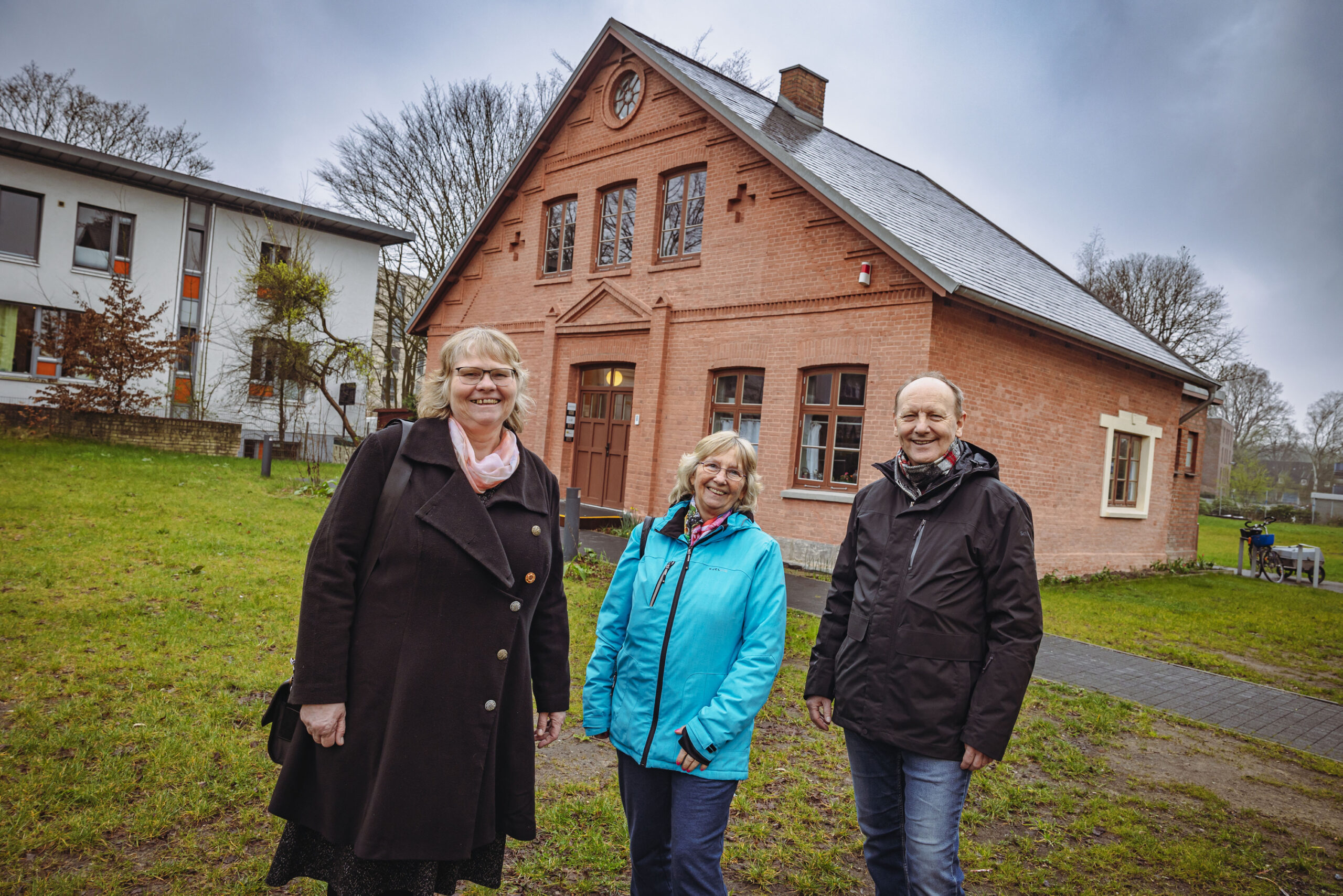 Die stolzen Bramfelder Gudrun Wohlrab (59, v.li), Sigrid Schorsch (70) und Klaus-Dieter Wach (71) stehen vor dem ehemaligen Försterhaus, in dem heute das Stadtteilarchiv sitzt.