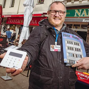 „Hinz&Kunzt“-Verkäufer Thomas mit seinem Kartenlesegerät und einigen Zeitschriften