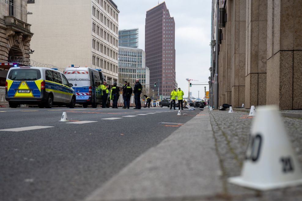 Polizisten stehen an einer Unfallstelle in der Leipziger Straße