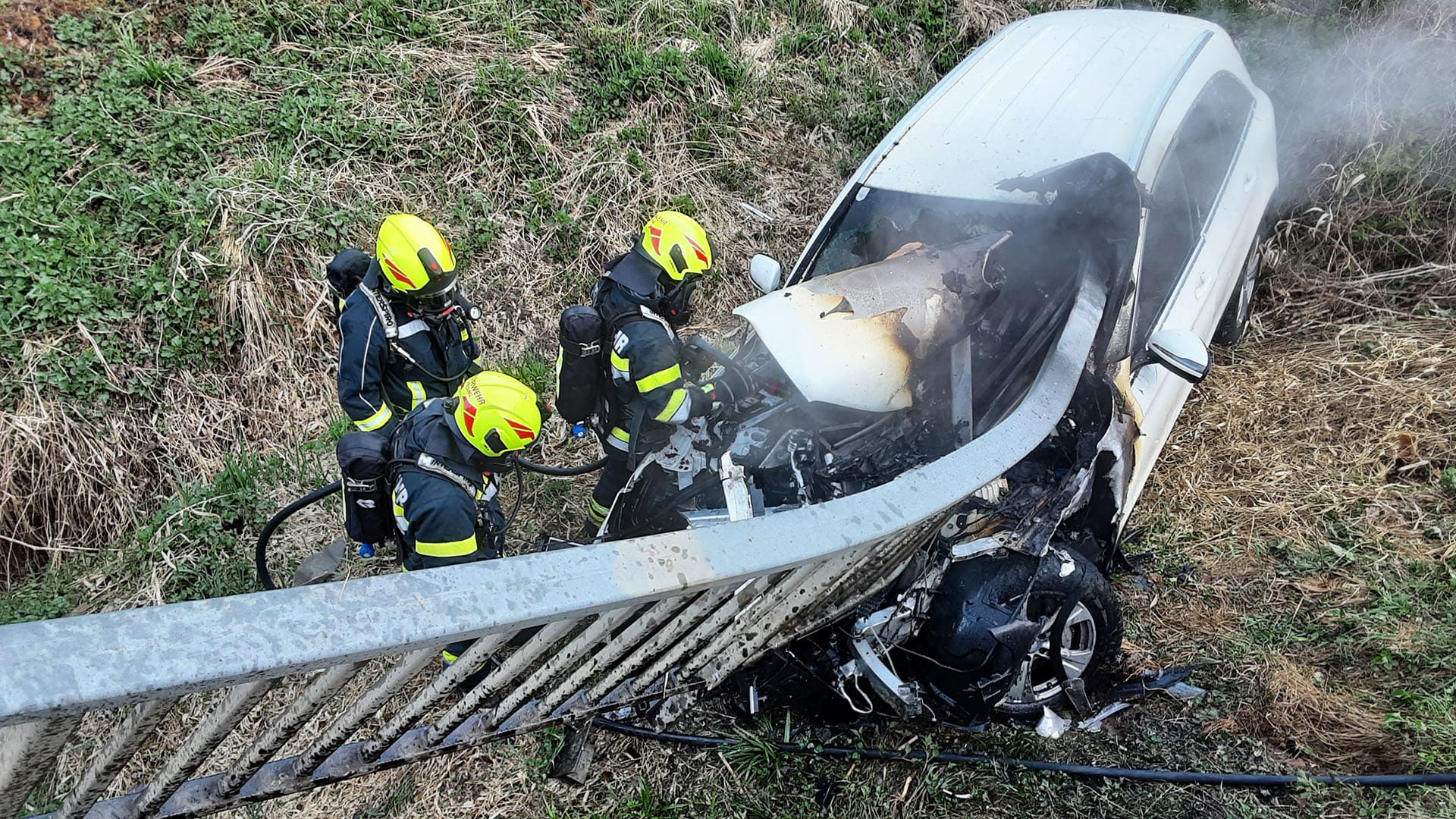 Feuerwehrleute der Freiwilligen Feuerwehr Preding löschen den Brand eines verunfallten Pkw nach dem schweren Autounfall in Hengsberg (Bezirk Leibnitz) in der Steiermark.