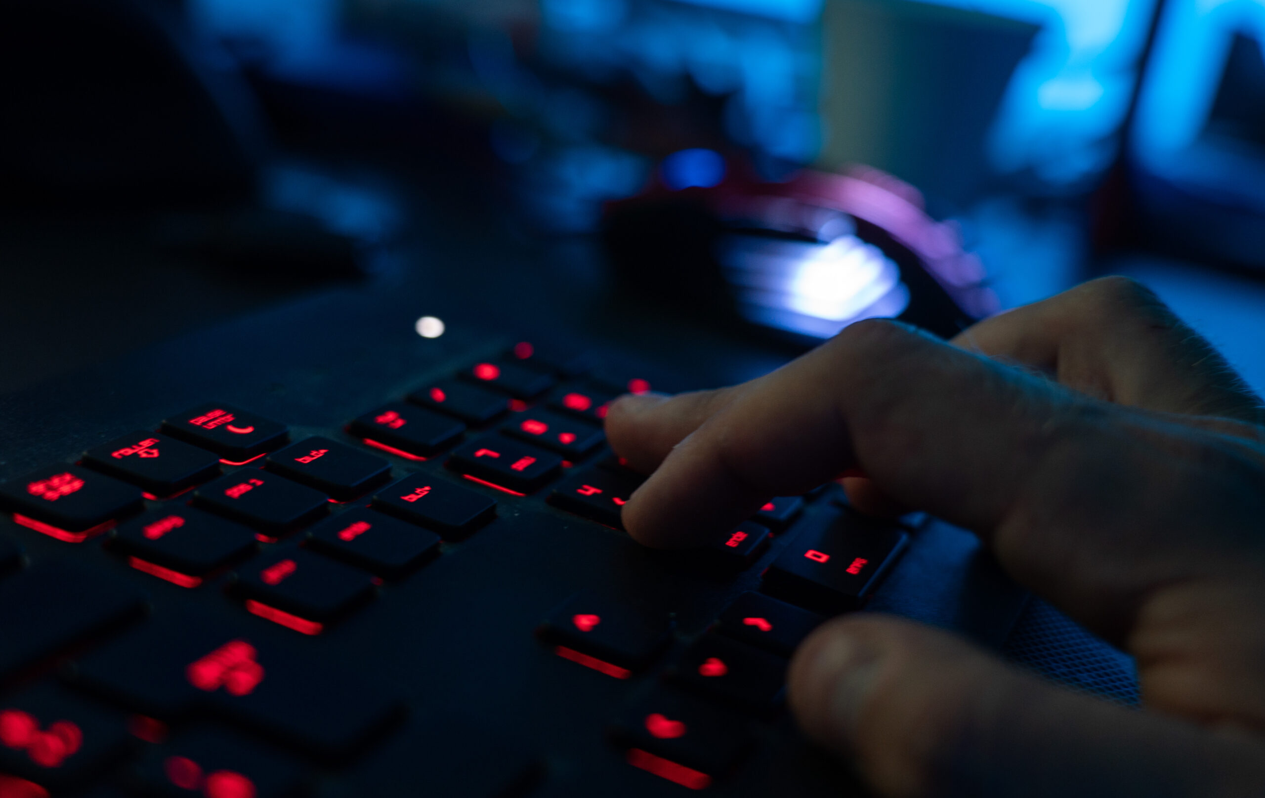 Ein Mann sitzt am Rechner und tippt auf einer Tastatur.