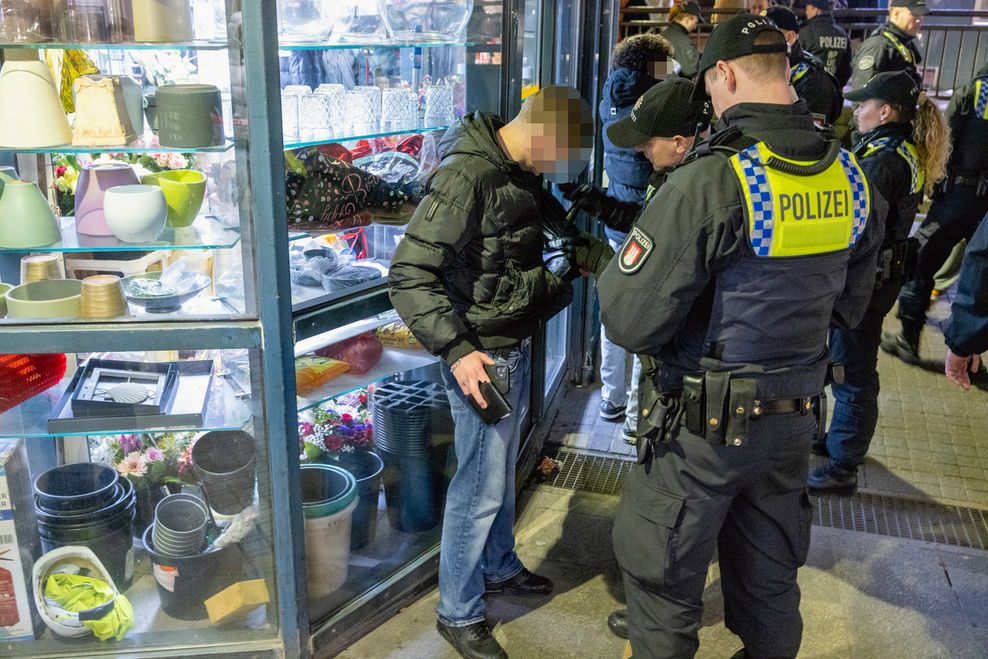 Polizisten kontrollieren einen Mann am Hauptbahnhof.