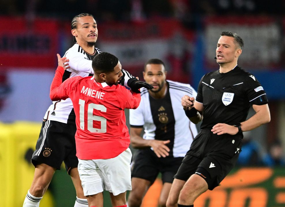 Leroy Sané (hinten links) trifft Mwene mit der Hand im Gesicht.