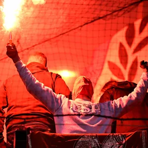 Ein Rostock-Fan hält Pyrotechnik in die Höhe