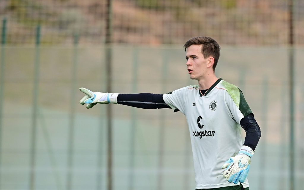 Kevin Jendrzej gibt im St. Pauli-Training eine Anweisung mit seiner rechten Hand