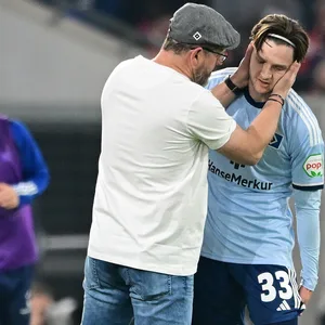 Steffen Baumgart legt seine Hände um den Kopf des verletzten Noah Katterbach