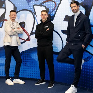 Claus Costa, Miro Muheim und Jonas Boldt posieren vor einer blauen Wand.