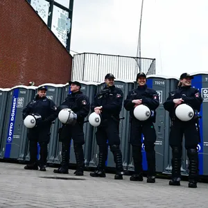 Polizisten warten vor den Dixi-Klos für die Rostocker