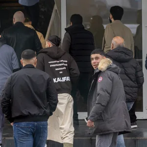 Männliche Islamisten betreten eine Halle.