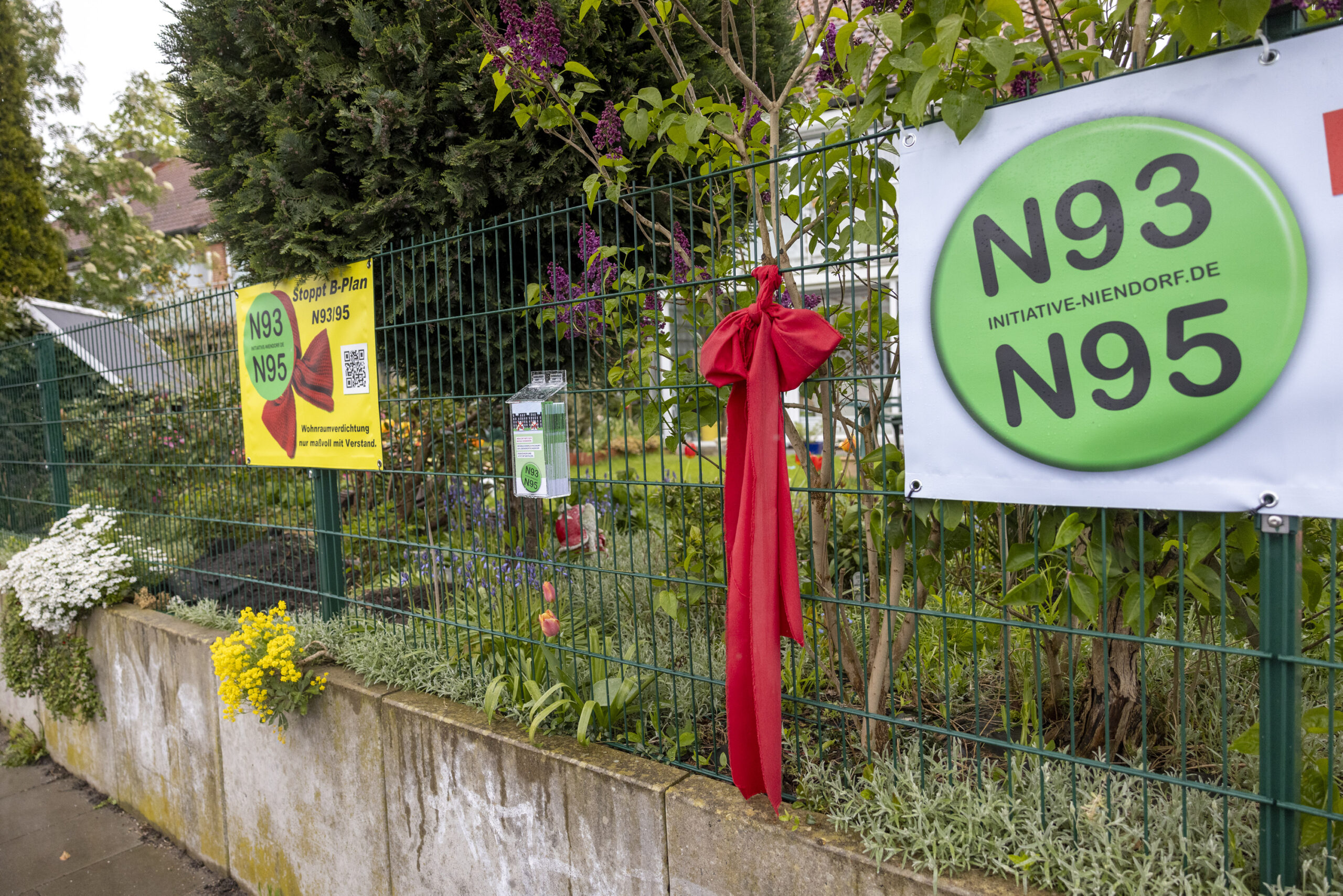Ein roter Schal ist in Niendorf an einen Zaun geknüpft.