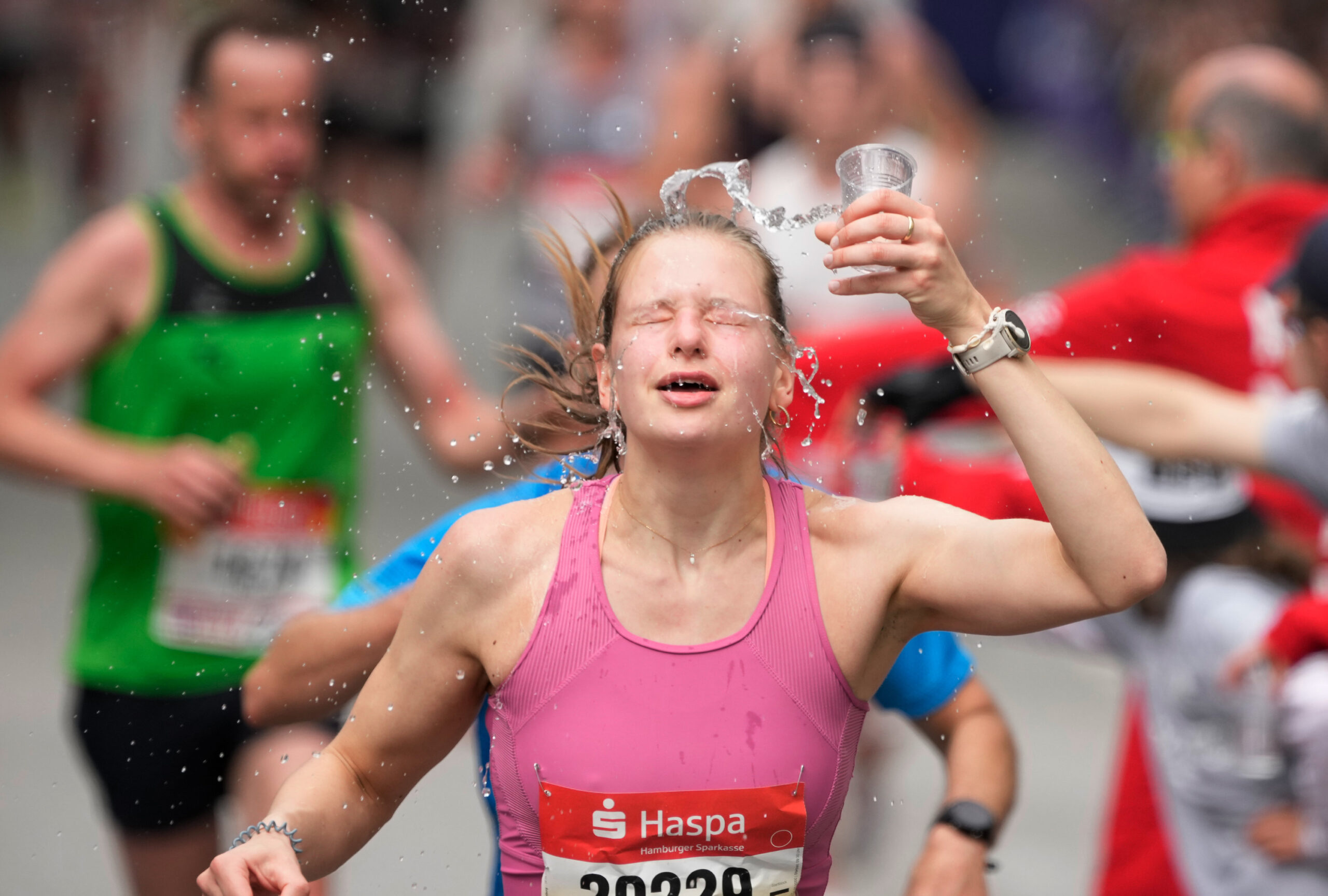 Marathonläuferin kippt sich Wasser über den Kopf