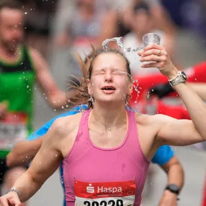 Marathonläuferin kippt sich Wasser über den Kopf