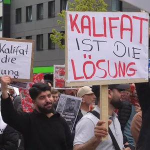 Männer halten Schilder hoch: „Das Kalifat ist die Lösung“