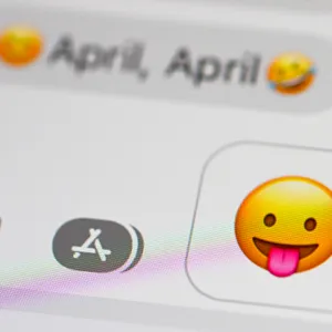 Auf einem Smartphone sind als Message „April, April“ und ein Smiley zu sehen, der die Zunge herausstreckt.
