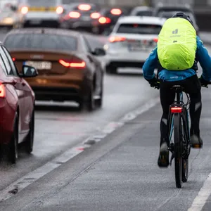 Ein Radfahrer fährt bei einsetzendem Eisregen über eine Brücke. Am Montag kann es glatt werden auf den Straßen.