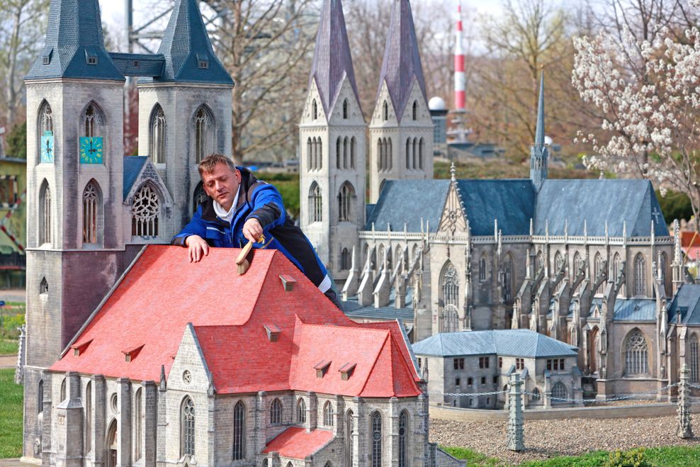 Mitarbeiter des Miniaturenparks Kleiner Harz stellen ein Modell der Martinikirche Halberstadt auf.