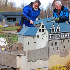 Mitarbeiter des Miniaturenparks Kleiner Harz stellen ein Modell der Burg Falkenstein auf.