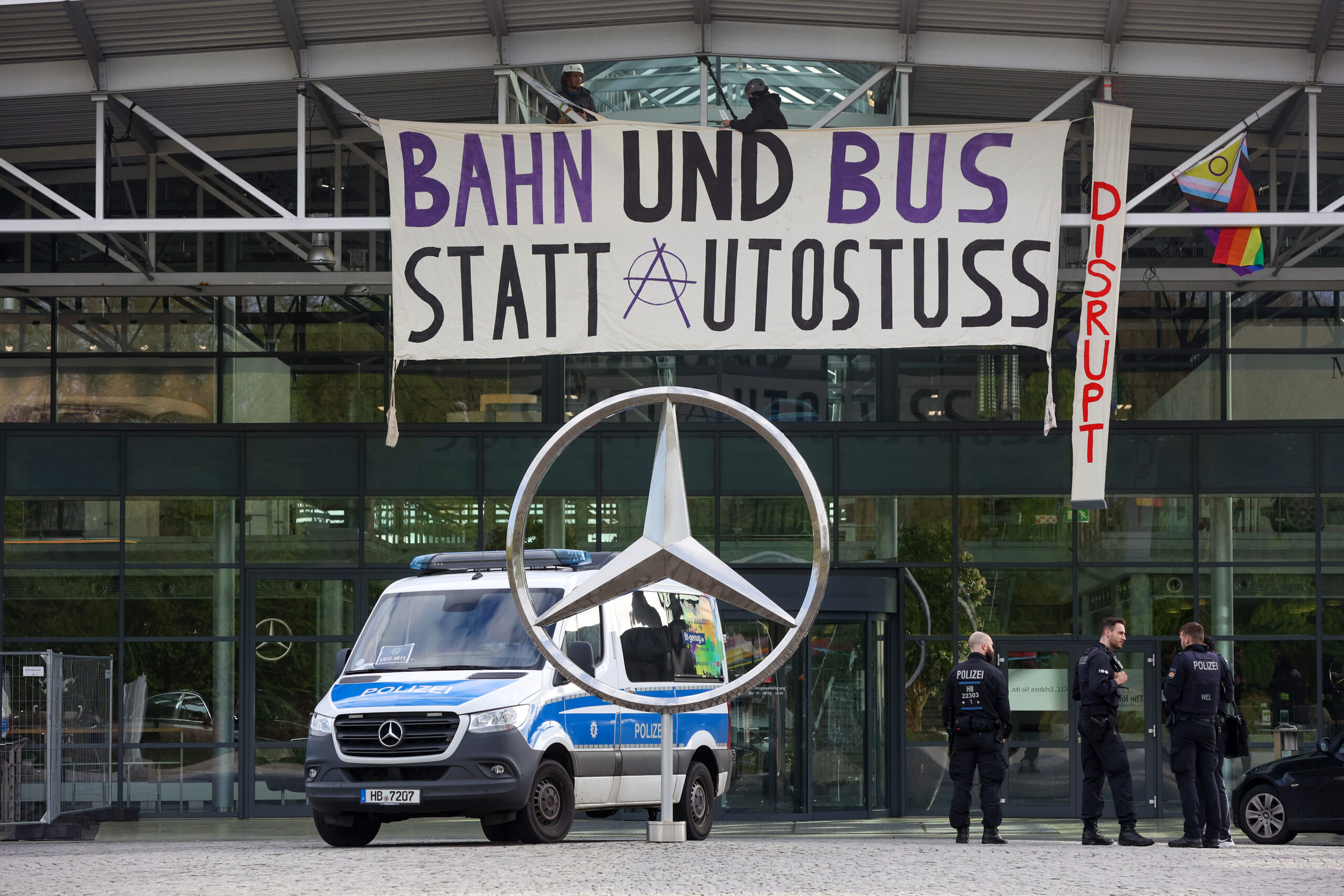 Polizeiwagen vor dem Mercedes-Gebäude mit Banner