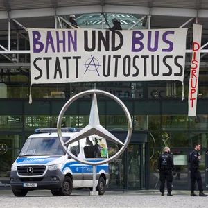 Polizeiwagen vor dem Mercedes-Gebäude mit Banner