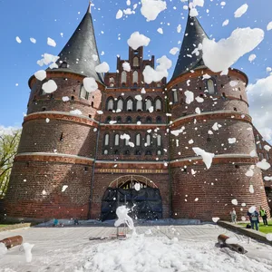 Weißer Schaum fliegt bei einem Testlauf für eine Kunstaktion vor dem Holstentor durch die Luft.