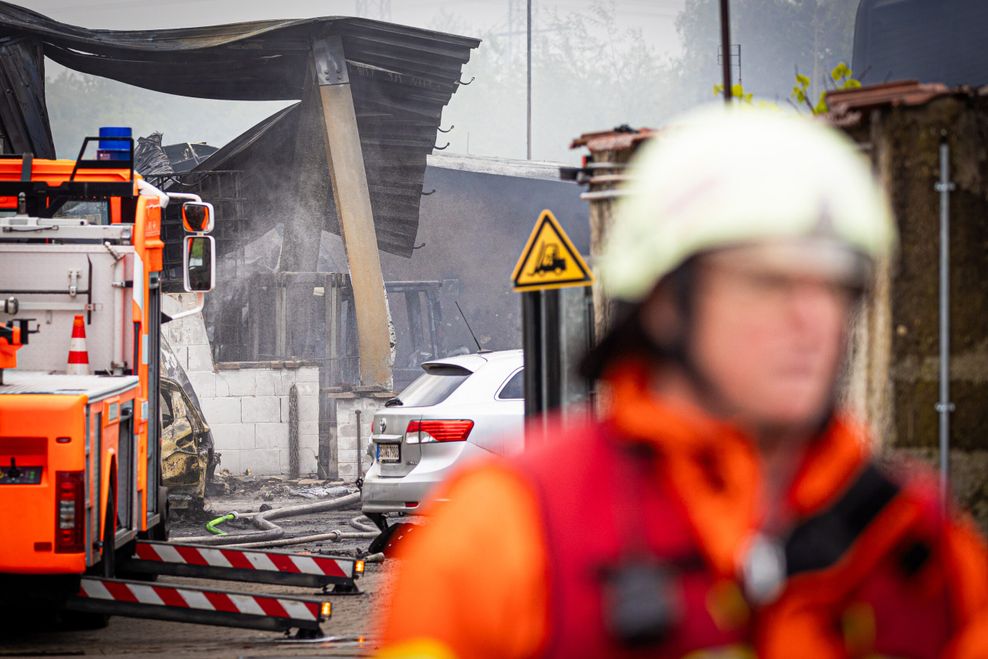 Einsatzkräfte und -fahrzeuge der Feuerwehr stehen bei einem Großbrand in einem Braunschweiger Industriegebiet.