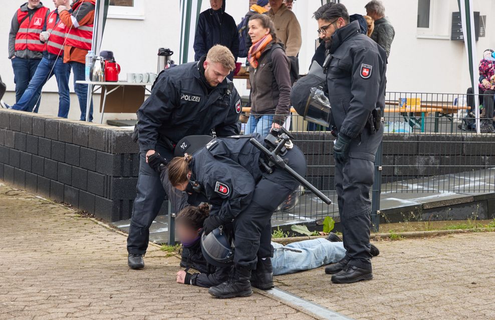 Polizisten stehen während der Demonstration gegen den AfD-Parteitag um eine Person am Boden.