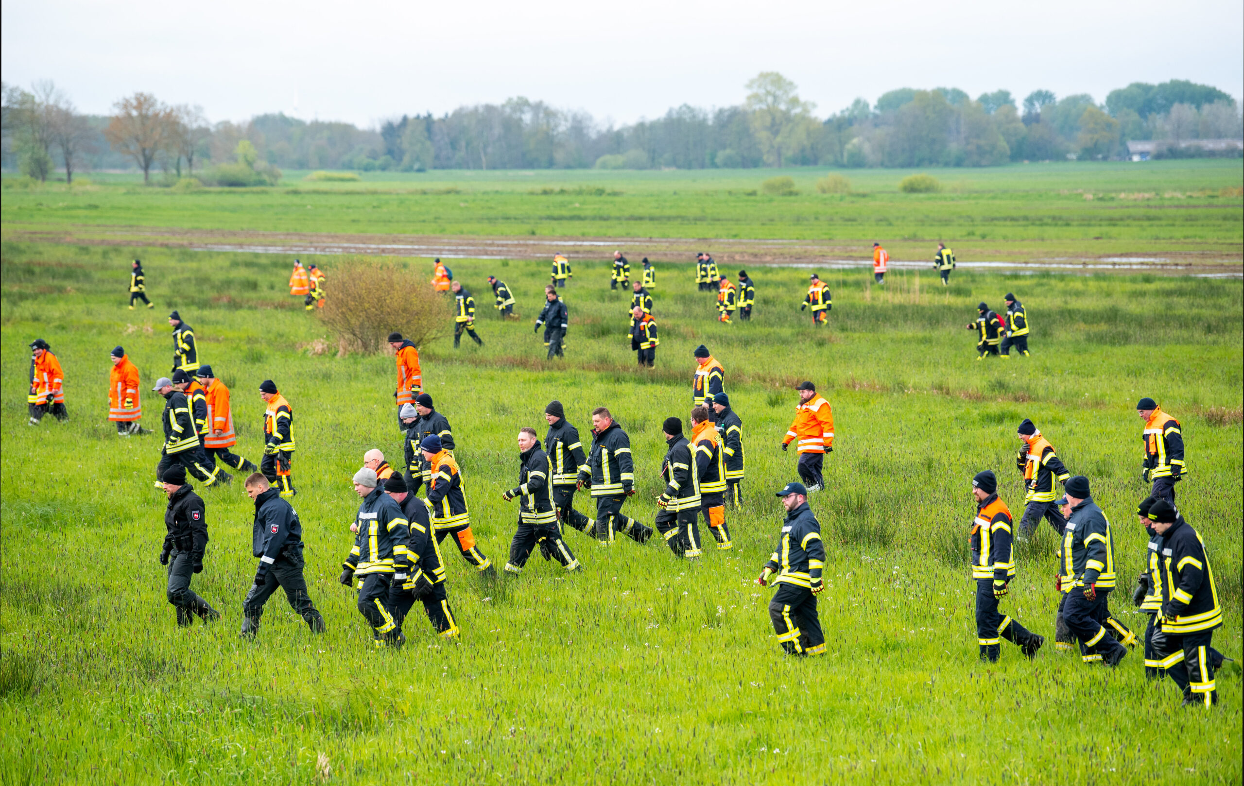 Einsatzkräfte laufen über ein Feld