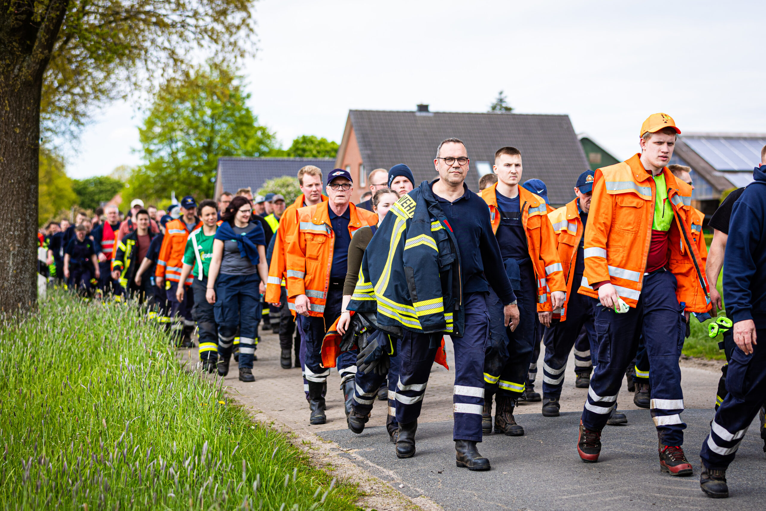 Einsatzkräfte der Feuerwehr gehen eine Straße im Landkreis Stade entlang. Der sechs Jahre alte Arian aus Elm wird weiter vermisst.