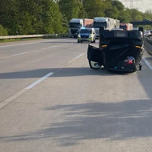 Rettungskräfte versorgen den verletzten Fahrer. Bei dem Unfall überschlug sich das Fahrzeug und kam auf dem Dach liegend zum Stehen.
