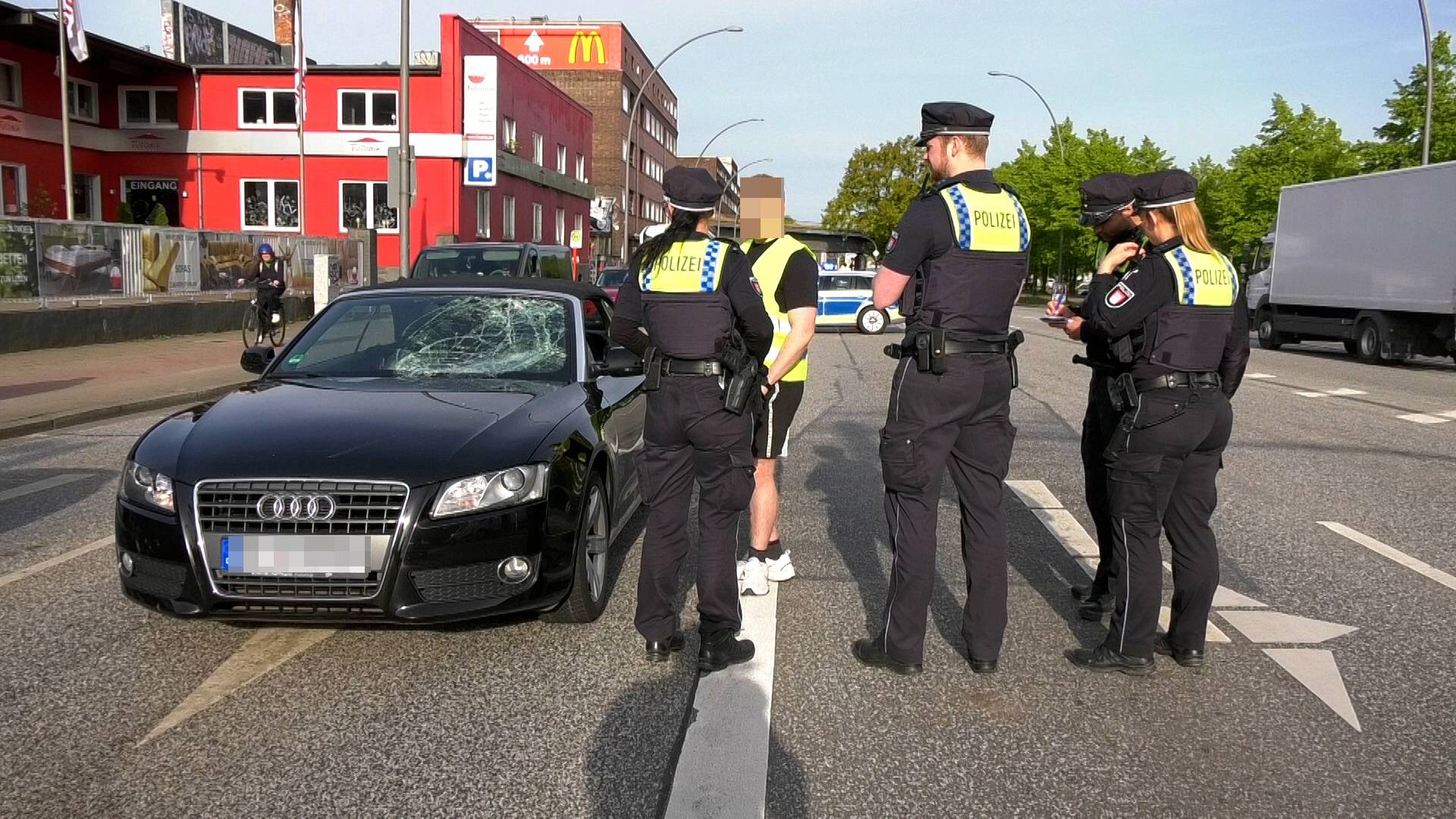 Polizisten sprechen mit dem Fahrer des Audis.