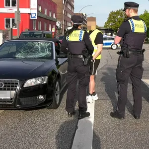 Polizisten sprechen mit dem Fahrer des Audis.