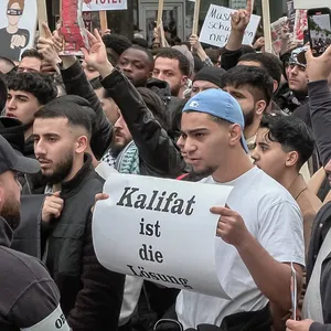 Männer auf Demo mit Schild: „Kalifat ist die Lösung“