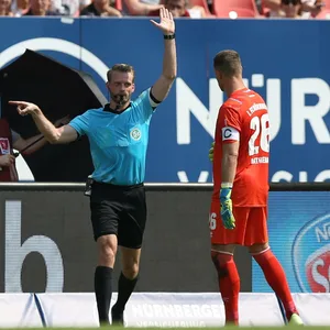 Schiedsrichter mit Nürnbergs Torwart Christian Mathenia